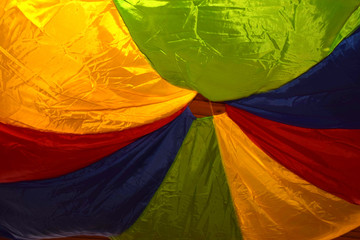 colorful game parachute made of thin silk attached to the ceiling, indoor parachute for games