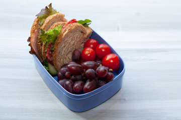 Lunch box with sandwich and fruit.