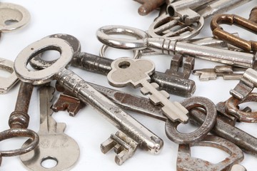 a heap of different old keys are lying in the white studio