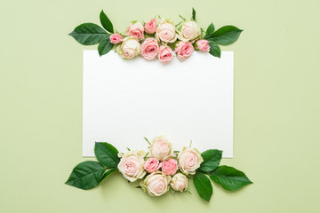 greeting card mockup. empty white paper with roses arrangement on green background