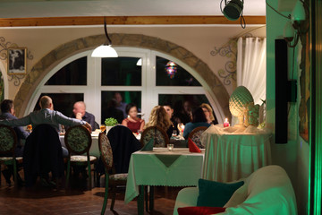 Ludzie na przyjęciu w restauracji, pięknie zaprojektowany wystrój wnętrza. - obrazy, fototapety, plakaty