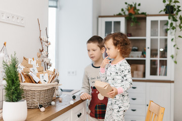 Children in pajamas and advent calendar with small gifts