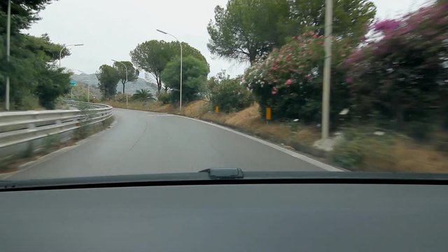 Driving out of Taormina to get on highway. Sicily, Italy. Signs for Catania and Messina. Some smudges on windshield.