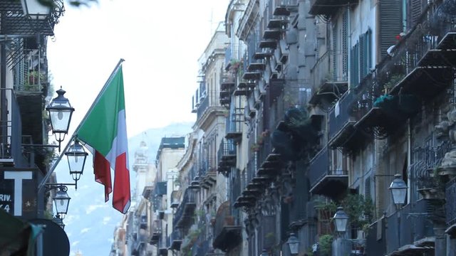 Italian flag hanging over Via Vittorio Emanuele street in Palermo, Sicily, Italy.