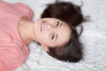 close up.thoughtful young woman lying on white carpet in living room