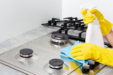 Cleaning a gas stove with kitchen utensils, household concepts, or hygiene and cleaning.