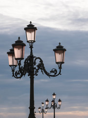 Street light lanterns or lamps against the blue sky. Scenic view of vintage lanterns isolated on sky background. No people.