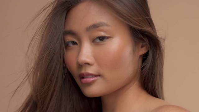 beauty asian thai model with straight hair blowing in aid closeup portrait