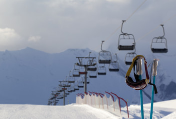 Fototapeta na wymiar Snowy skiing slope, chair-lift and ski mask on ski poles
