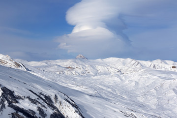 Snowy winter mountains and blue sky with beautiful clouds at nice sun day