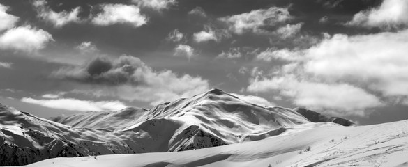 Black and white ski slope and beautiful sky with clouds in sun evening