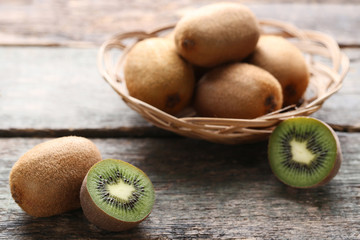 Kiwi fruits in basket on wooden table