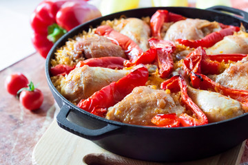 Chicken thighs and legs baked over a bed of rice and red bell pepper