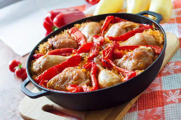 Chicken thighs and legs baked over a bed of rice and red bell pepper