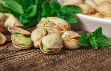 Bowl with pistachios on a wooden table.