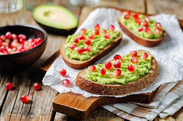 Smashed avocado pomegranate rye sandwiches