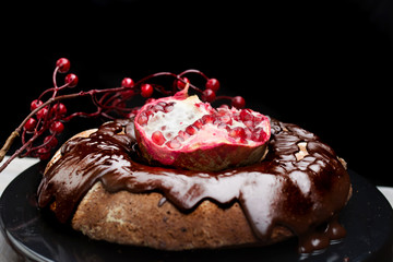 Fototapeta na wymiar Homemade chocolate cake with pomegranate on wooden background