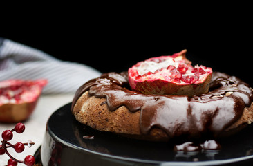 Homemade chocolate cake with pomegranate on  wooden background