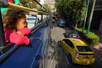 Little blonde little girl in a tourist bus in Athens