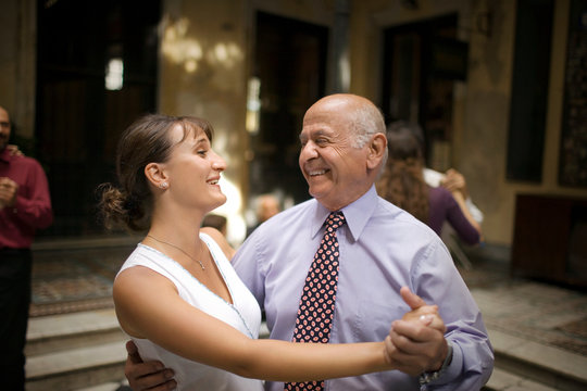View of an elderly man dancing with a woman.