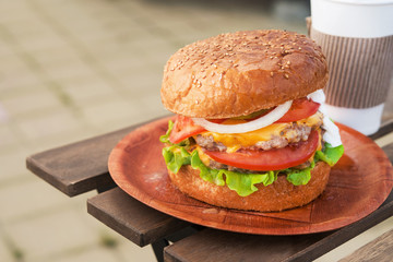 Tasty and succulent burger with paper coffee cup