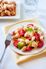 Salad with three kinds of tomatoes, boiled white kidney beans and croutons from white bread