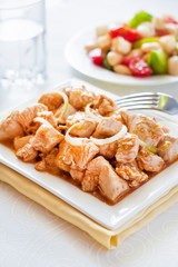 Turkey stew in tomato mustard sauce with onion on square plate