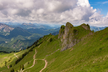 Rotwand vor Bergpanorama mit Wolken und Himmel