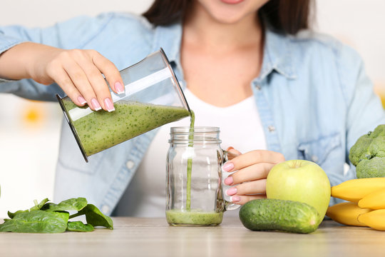 Woman Pouring Smoothie In The Glass Jar