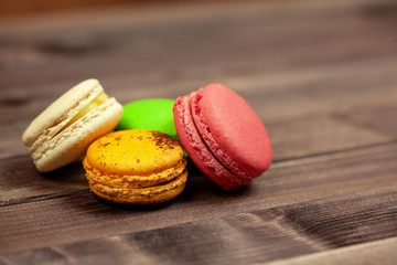 Colorful macaroons on wooden background. French dessert macaroons