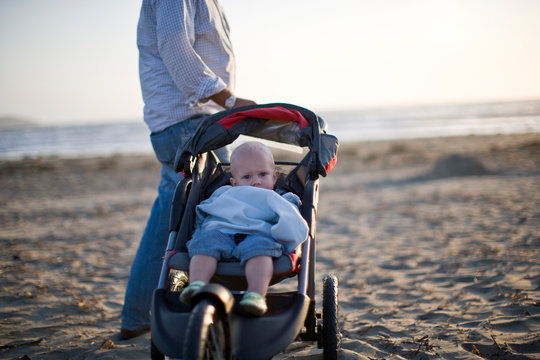 Man with son in pushchair on the beach