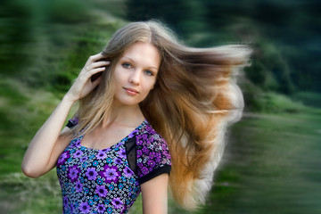 Naklejka premium Portrait of a beautiful girl with long hair in a meadow