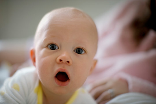 Portrait of a young baby looking surprised.