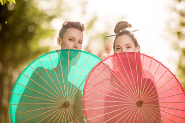 Beautiful  two women  in park wearing kimano and holding umbrella