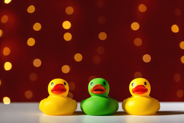 Rubber duck toys on a shiny light dark red background
