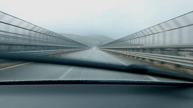 Crossing long bridge in the rain. Driving from Messina to Palermo on Autostrada E90, Sicily, Italy.
