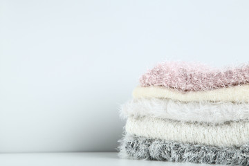 Stack of folded sweaters on grey background