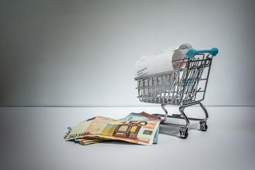 Shopping cart with purchased receipt and euro bills