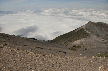 Irazu volcano in Costa Rica. Crater in clouds with protective barriers. Fragments of lava and pumice.