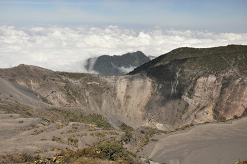 Irazu volcano in Costa Rica. Crater in clouds with protective barriers. Fragments of lava and...
