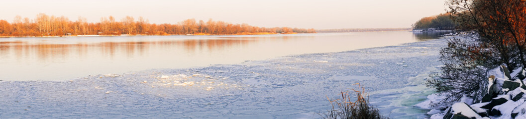 Beautiful winter landscape. Trees reflected in the water of the lake