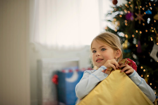 Young girl opening a present on Christmas Day.