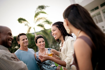 Group of friends talking together in the back yard.