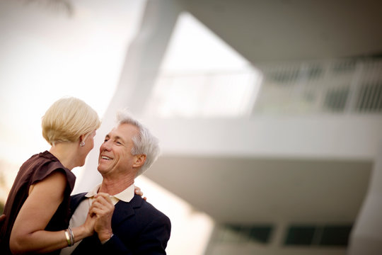 Husband and wife dancing together in their front yard.