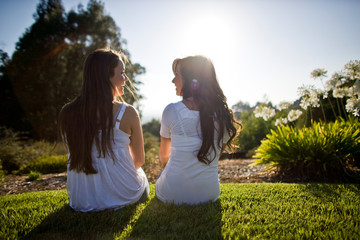 Two teenage girls sitting in the garden.