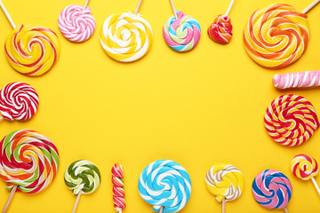 Fototapeta na wymiar Colorful lollipops on yellow background