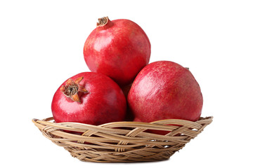 Ripe pomegranate in basket isolated on white background
