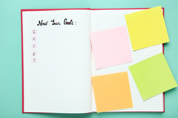 New year goals in notepad on mint background