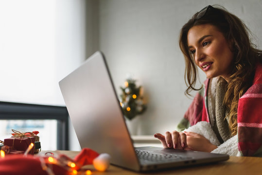 Young woman buying online at home  for winter holidays using laptop computer. 
