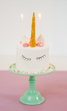 Unicorn cake with fondant and mini marshmallows on turquoise cake stand